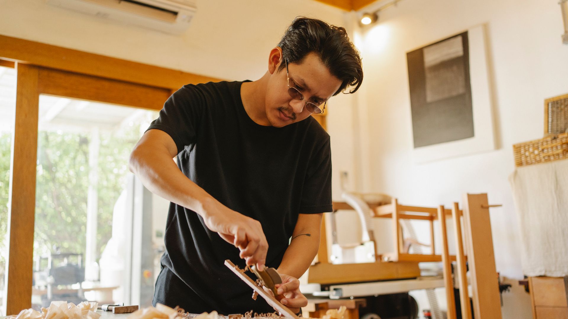 Craftsperson shaping timber carefully with a hand plane