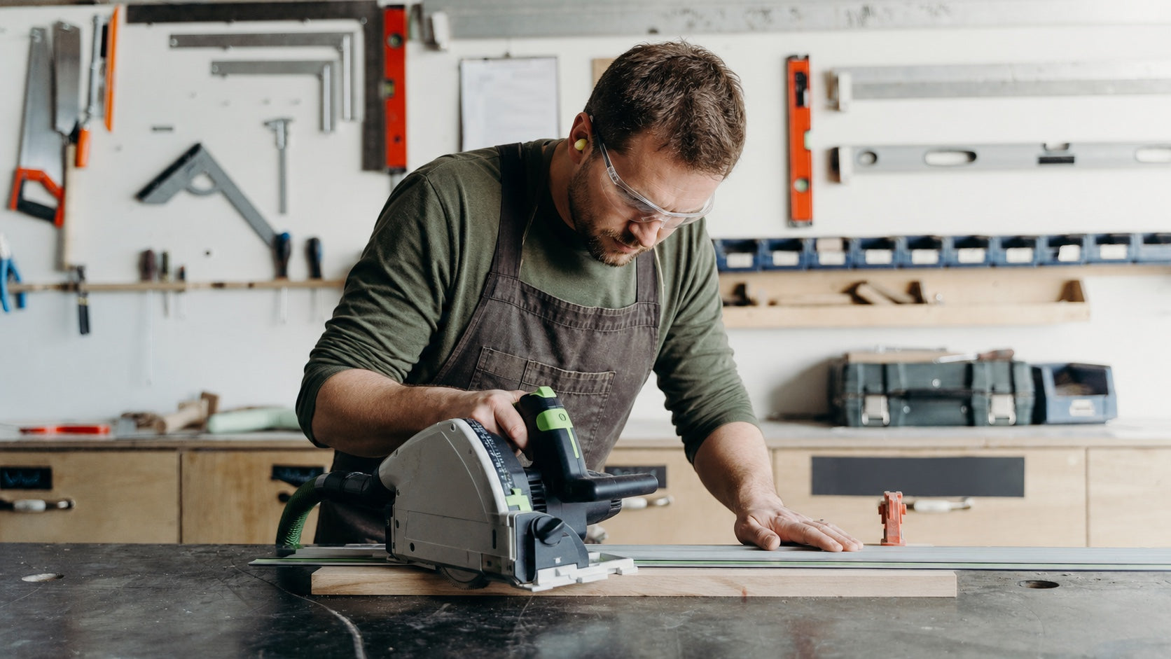 Carpenter using a track saw safely in a bright workshop